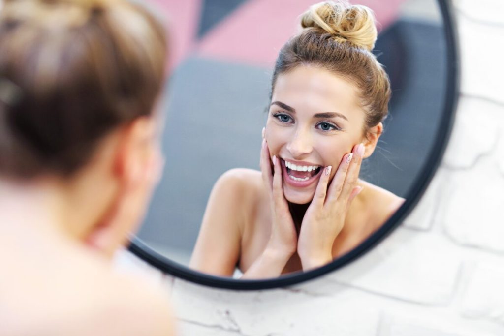 簡単に実践できる笑顔美人になるための手順
自分の笑顔を知る
自分を鏡で見る笑顔の女性
